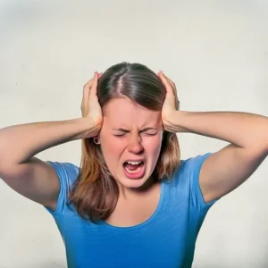 Woman covering ears in frustration due to noise - Misophonia concept